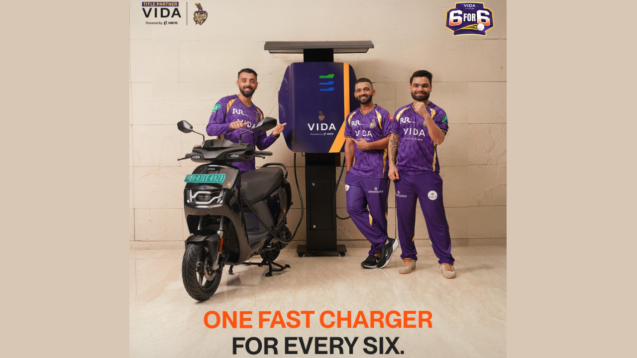 Kolkata Knight Riders players posing with VIDA electric scooter and fast charging station, promoting IPL campaign “One Fast Charger for Every Six”.