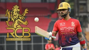Virat Kohli in Royal Challengers Bangalore jersey holding a cricket bat with RCB logo visible during an IPL match
