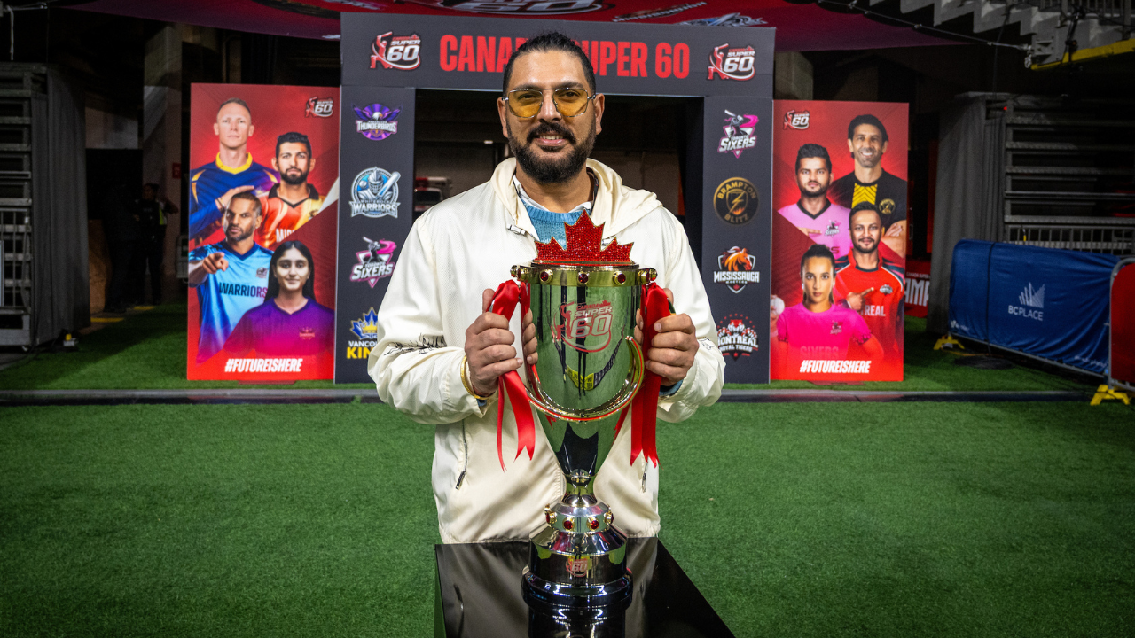 Yuvraj Singh holding Canada Super 60 cricket trophy during event launch with team posters in background