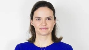Portrait headshot of Catherine Beloff wearing a blue top against a plain background