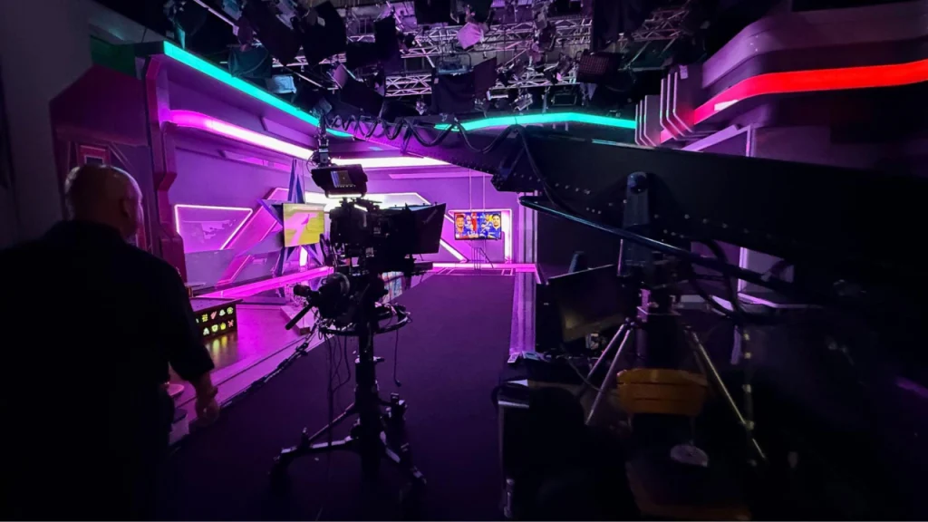 Modern cricket TV studio with broadcast cameras lighting rigs and production setup for live sports coverage