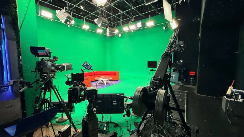 Professional TV studio with green screen setup cameras lighting rigs and production equipment for live broadcast