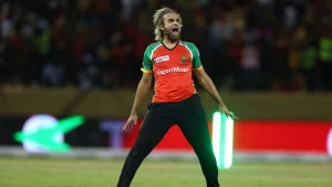 Imran Tahir celebrates during a CPL match wearing Guyana Amazon Warriors jersey on the field.