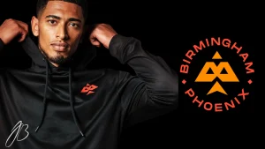 Jude Bellingham wearing black hoodie alongside Birmingham Phoenix logo on dark background.