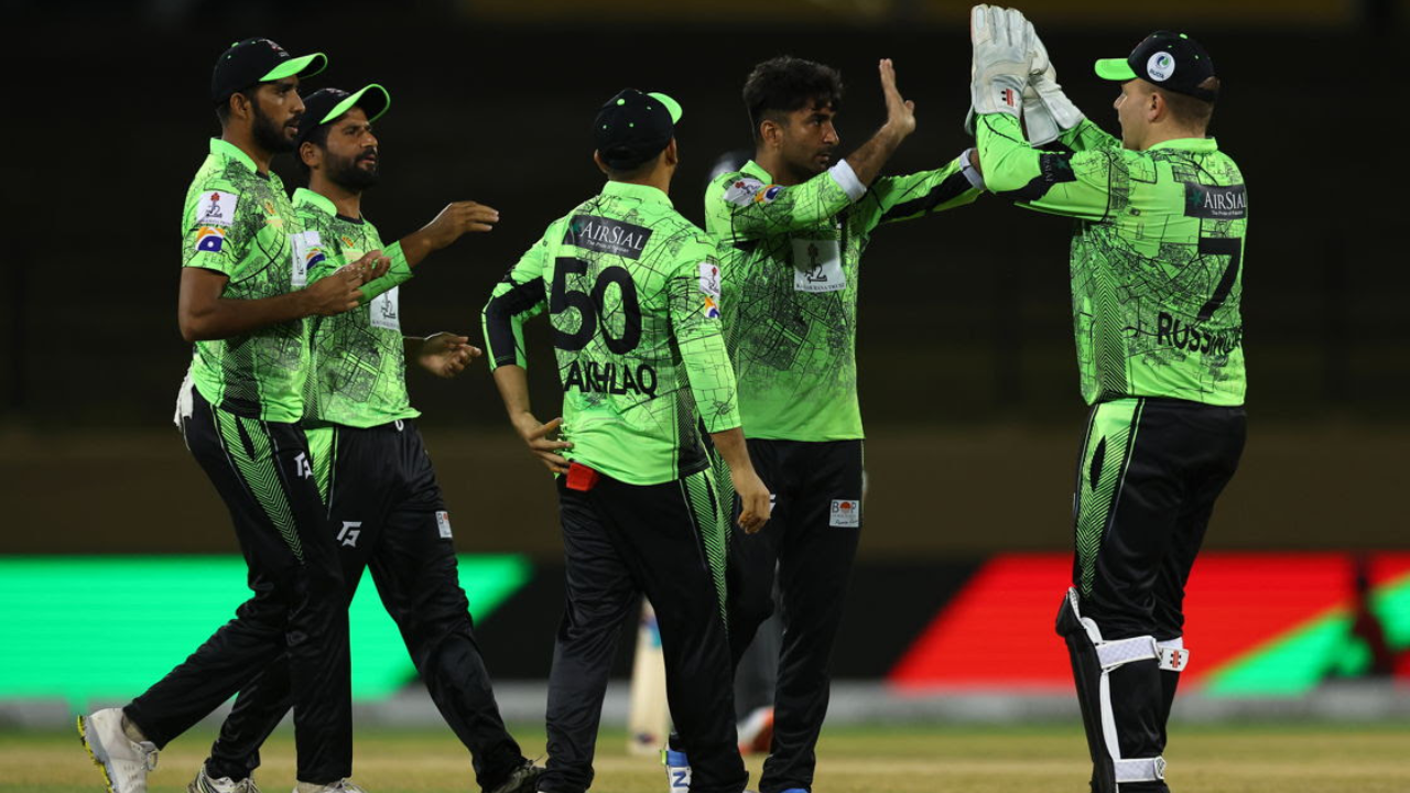 Lahore Qalandars players celebrating a wicket with high-fives during a PSL cricket match in green team kits
