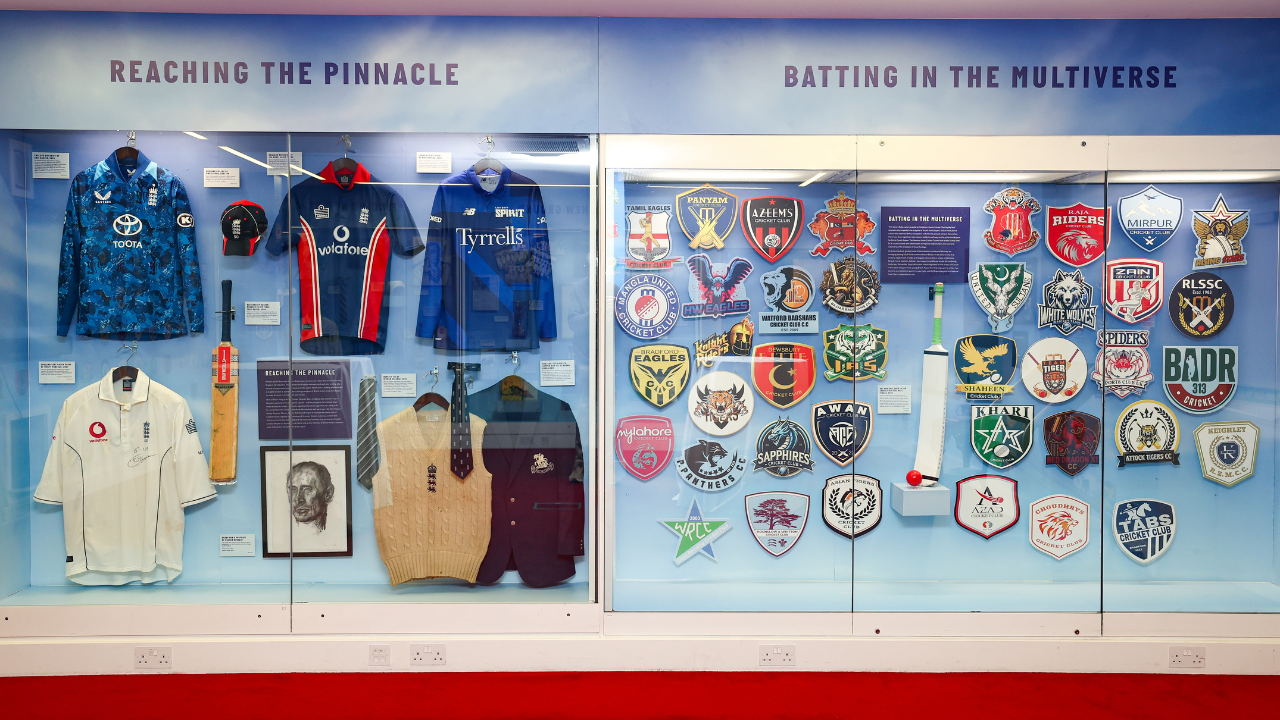 Exhibit display inside MCC Museum at Lord’s Cricket Ground showcasing historic England cricket jerseys, bats and club badges