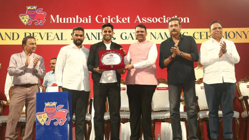 Mumbai Cricket Association ceremony featuring Devendra Fadnavis, Sunil Gavaskar, Suryakumar Yadav, Ravi Shastri, Ashish Shelar and Ajinkya Naik during an award presentation on stage.