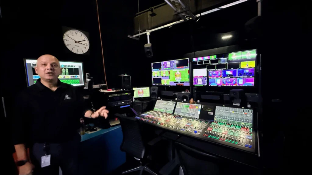 Prashant Khanna in broadcast control room with live production monitors and audio mixing console setup