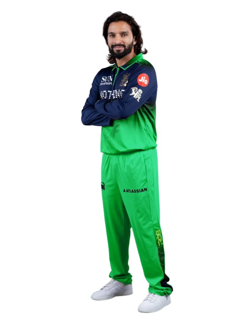 Rajat Patidar posing with arms crossed in RCB green jersey during IPL photoshoot on white background