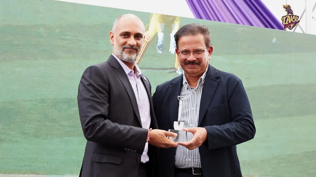 Sanjog Gupta and Knight Riders Group CEO Venky Mysore at cricket event exchanging memento on stage.