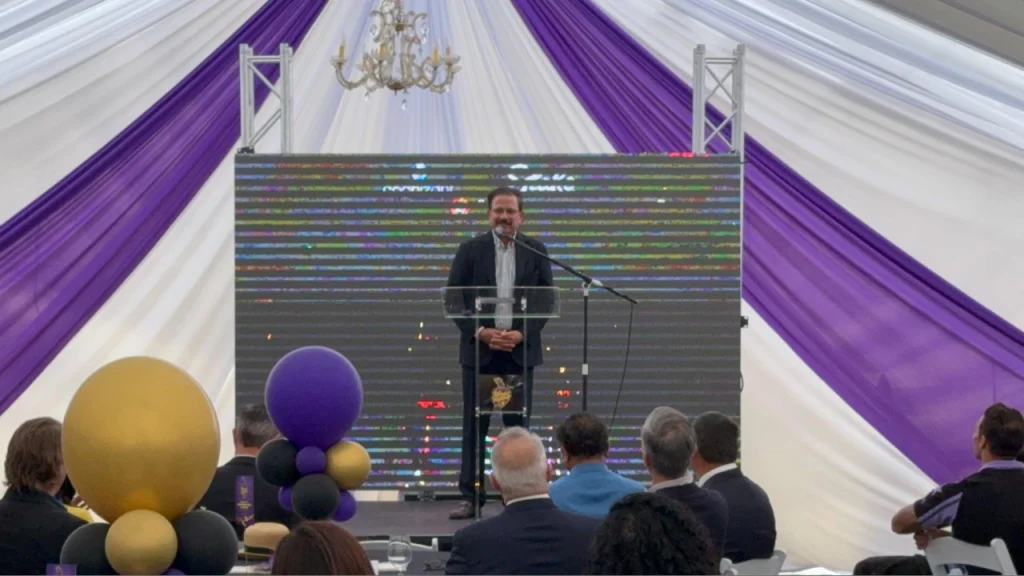Knight Riders Group CEO Venky Mysore speaking at groundbreaking ceremony addressing guests from podium.