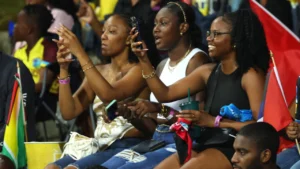 Fans enjoying the atmosphere during a Caribbean Premier League match with supporters waving national flags in the crowd
