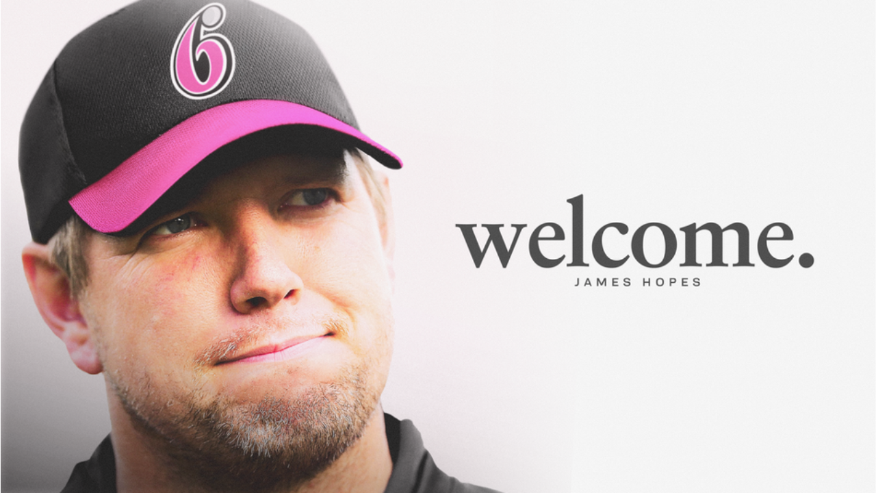 Portrait of James Hopes, Sydney Sixers head coach, wearing team cap with welcome text in background