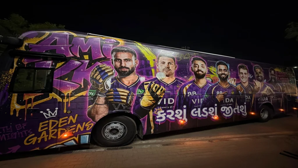 Kolkata Knight Riders team bus with Eden Gardens graffiti-style artwork featuring multiple KKR players at night in Kolkata