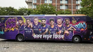 Kolkata Knight Riders team bus with graffiti-style artwork featuring multiple KKR players and branding during IPL season