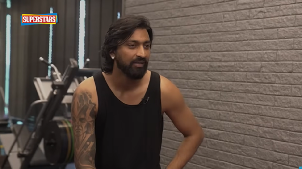 Krunal Pandya speaking during JioStar’s Superstars interview session in a gym setting wearing a black sleeveless shirt.