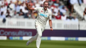 New Zealand fast bowler celebrates after taking a wicket during a Test cricket match with a cheering crowd in the background.