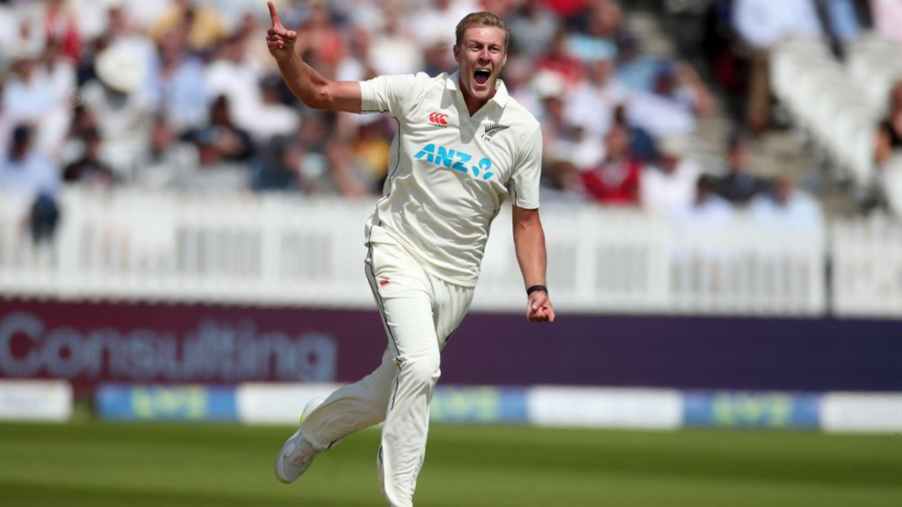 New Zealand fast bowler celebrates after taking a wicket during a Test cricket match with a cheering crowd in the background.