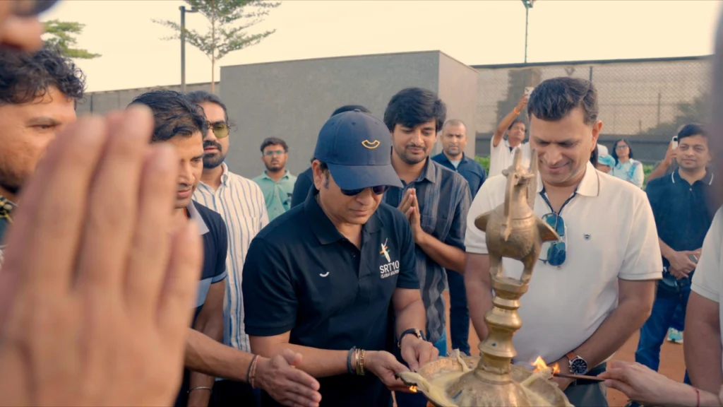 Sachin Tendulkar participating in a ceremonial lamp lighting during an event at the SRT10 cricket academy in Ahmedabad