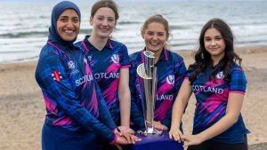 Scotland women’s cricket team players pose with the ICC Women’s T20 World Cup 2026 trophy on a beach ahead of the tournament.