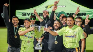 Tape ball cricket champions celebrating with a trophy and medals in front of a Sydney Thunder tent after winning a tournament.