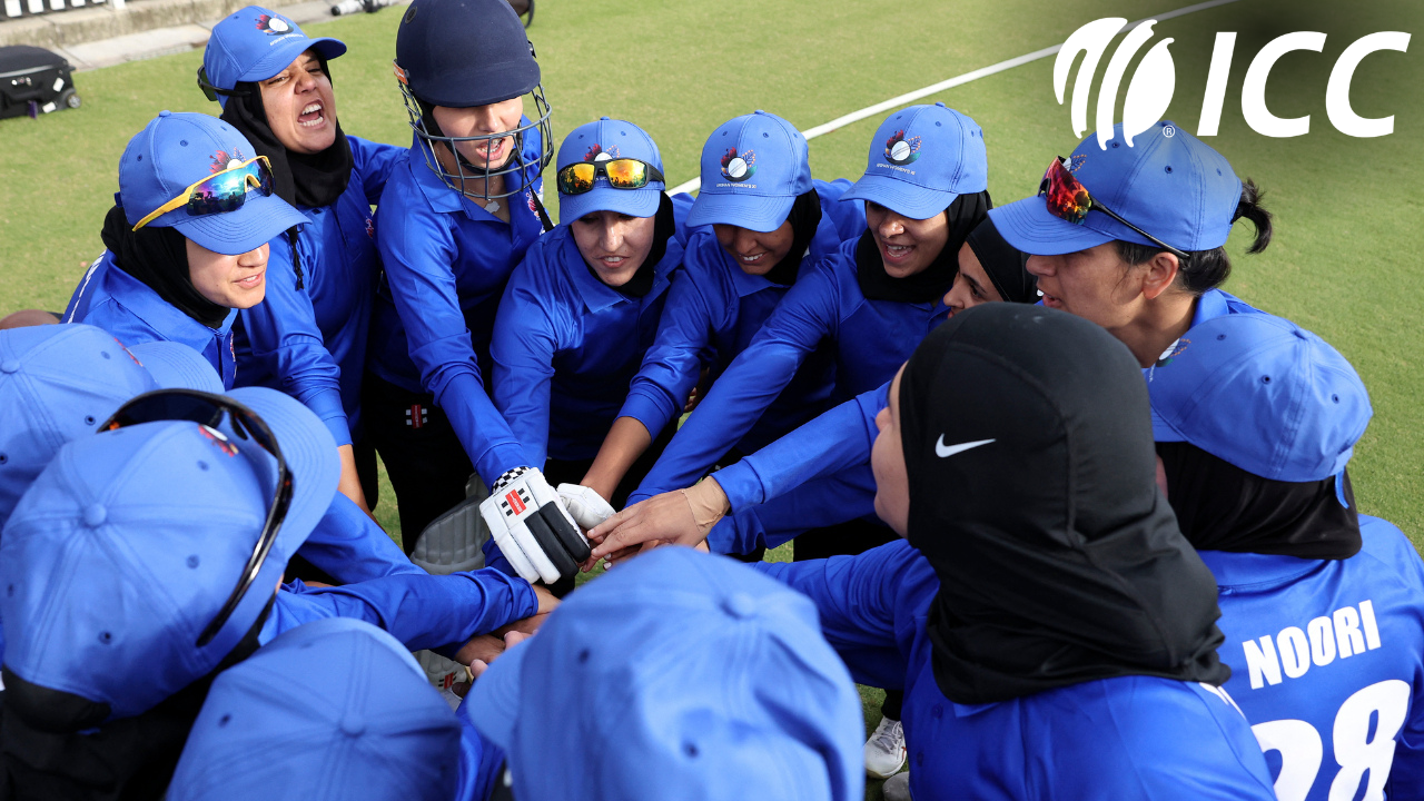 Afghanistan women's cricket team players gather in a team huddle during an ICC training session on the cricket field.