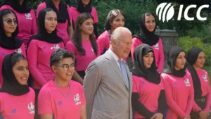King Charles III poses with members of the Afghanistan women's cricket team in a group photo alongside the ICC logo.