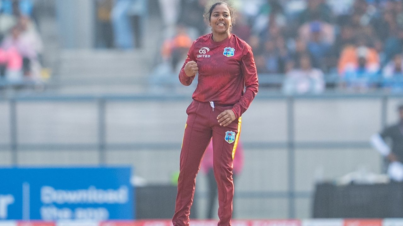 Afy Fletcher of the West Indies Women’s cricket team celebrates during a match, wearing the maroon team kit in front of a stadium crowd.