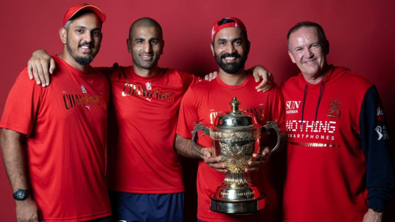 Dinesh Karthik, Mo Bobat and Andy Flower pose with the IPL trophy during a Royal Challengers Bengaluru promotional photoshoot.