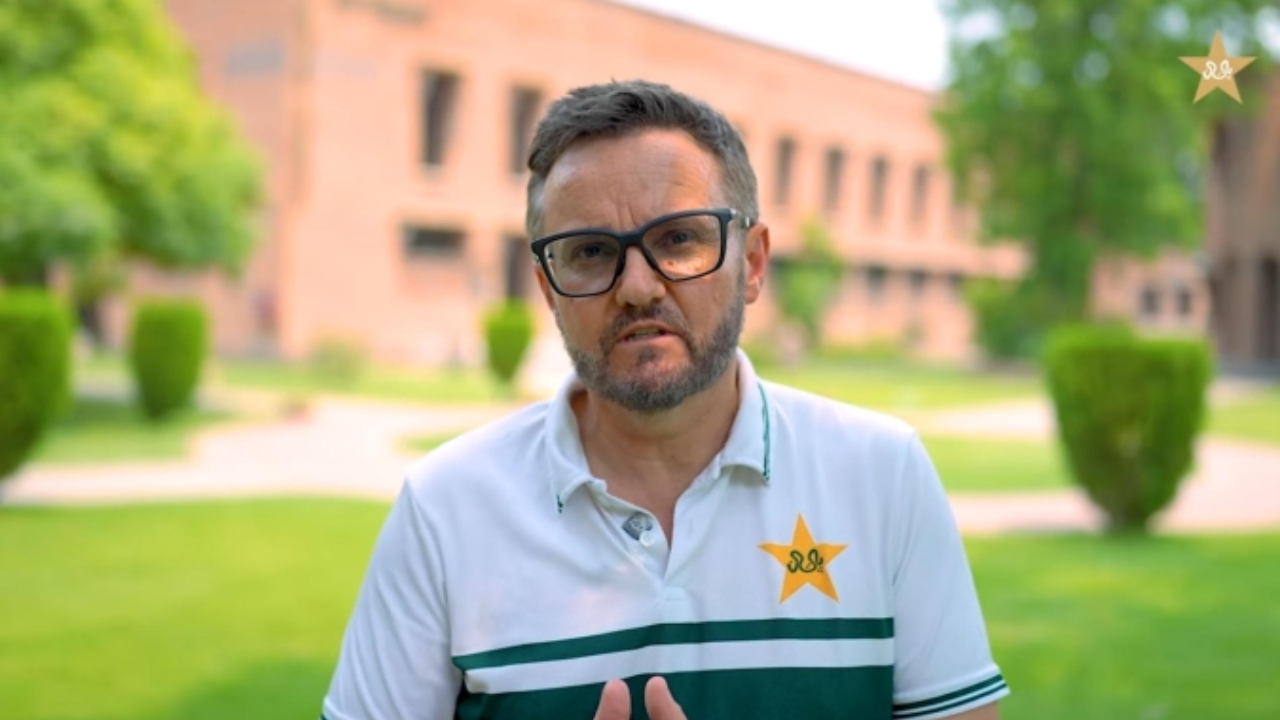 Mike Hesson wearing a Pakistan Cricket Board (PCB) polo shirt with the PCB logo during an outdoor interview.