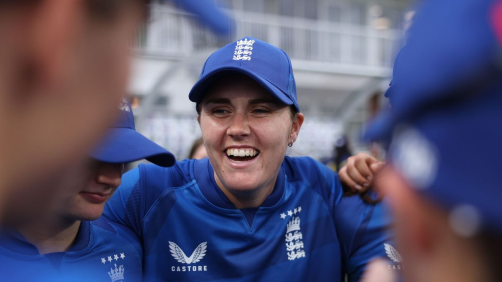 Nat Sciver-Brunt speaks to England women’s cricket team teammates during a pre-match huddle, wearing England’s blue training kit and captain’s cap ahead of an international fixture.