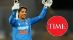 India women’s cricket star Smriti Mandhana celebrates with bat raised while wearing the India jersey, alongside the TIME magazine logo, highlighting her recognition and achievements in international cricket.