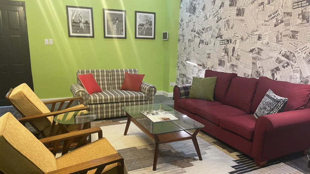 VIP lounge at the Sir Gary Sobers Sports Complex in Bridgetown, Barbados, featuring comfortable seating, cricket-themed decor, and a hospitality area for guests.
