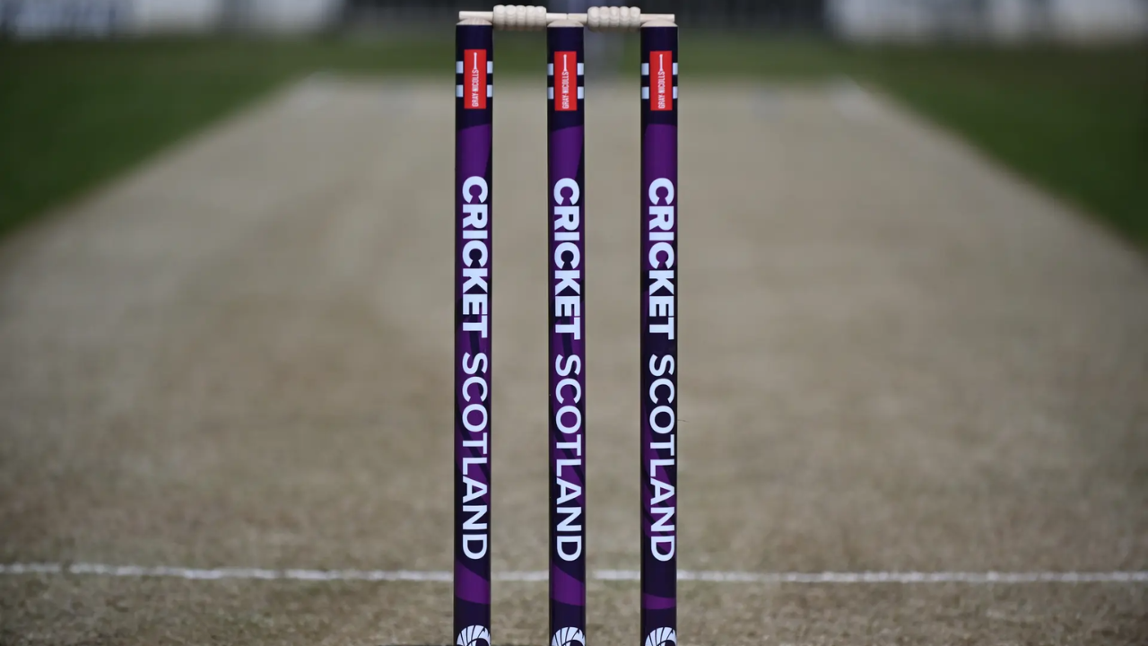 Cricket Scotland branded stumps standing on the pitch at a cricket ground before the start of a match.