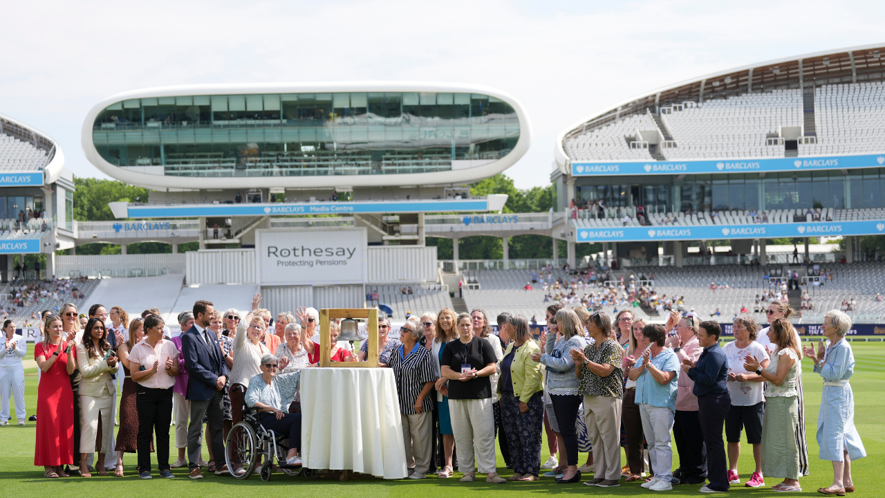 England former women’s cricket players, including eight members of the team that first walked onto the Main Ground at Lord’s in 1976, gather around a commemorative display during an anniversary celebration.