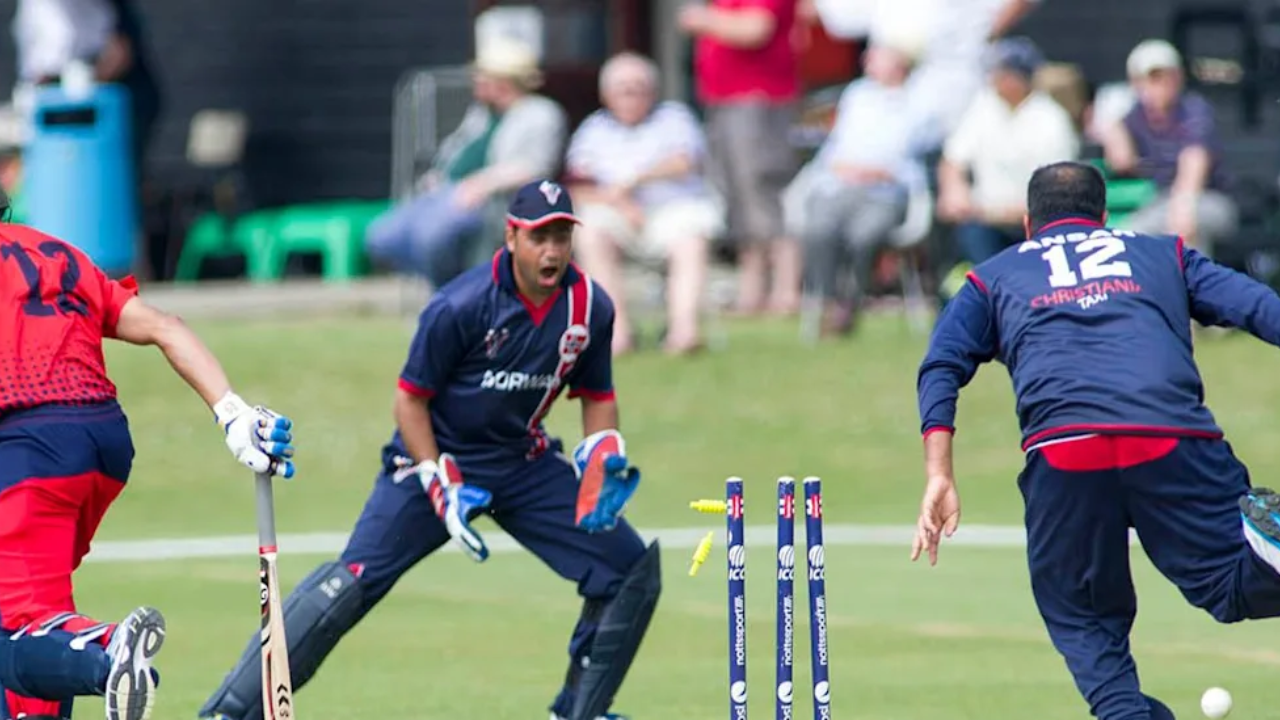 Players compete during an ICC Men’s T20 World Cup Europe Sub-Regional Qualifier B match in Denmark, with the wicketkeeper appealing after the stumps are broken.