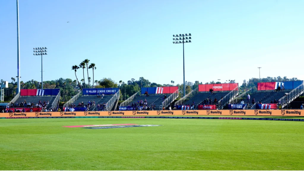 Wide view of Knight Riders Cricket Ground in Los Angeles during a Major League Cricket match, showing the outfield, spectator stands and stadium facilities.