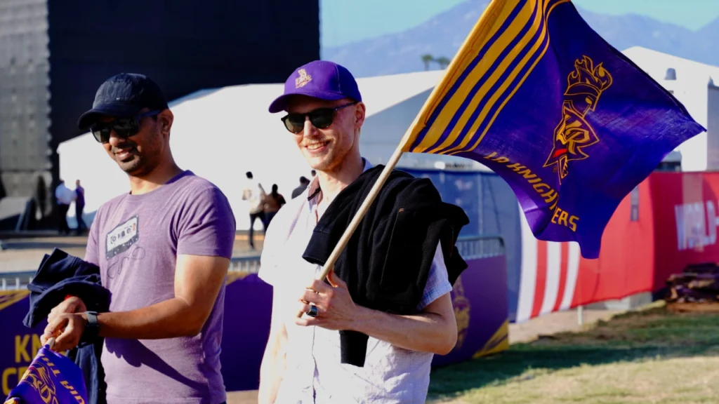 LA Knight Riders fans holding a team flag at Knight Riders Cricket Ground in Los Angeles during a Major League Cricket match.