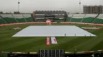 Gaddafi Stadium in Lahore with the cricket pitch covered during wet weather.