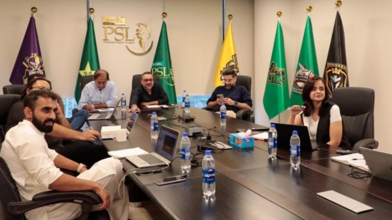 HBL PSL management, franchise representatives, and league officials attend a meeting in the Pakistan Super League boardroom with team flags displayed in the background.