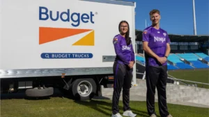 Hobart Hurricanes players pose beside a Budget Trucks vehicle at a cricket stadium