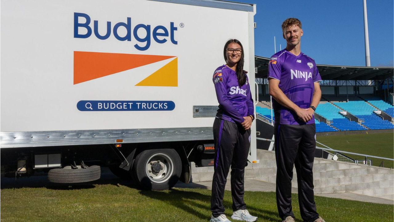 Hobart Hurricanes players pose beside a Budget Trucks vehicle at a cricket stadium