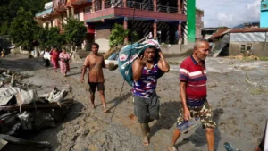 Residents walk through debris and mud following devastating flash floods in Nepal.