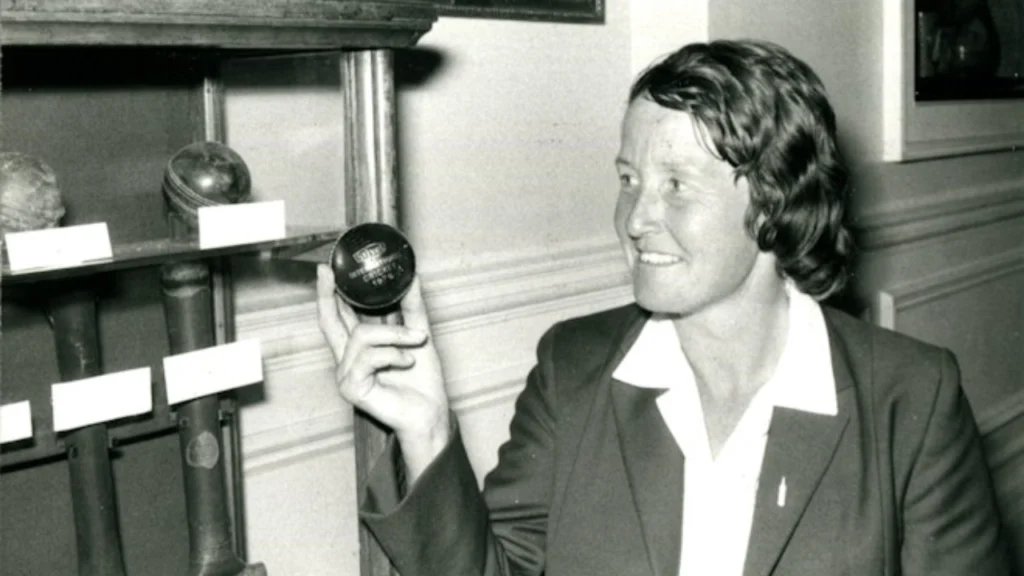 Rachael Heyhoe Flint holds a replica of the famous "Blue Ball," a historic symbol associated with women's cricket and the early development of the women's game.