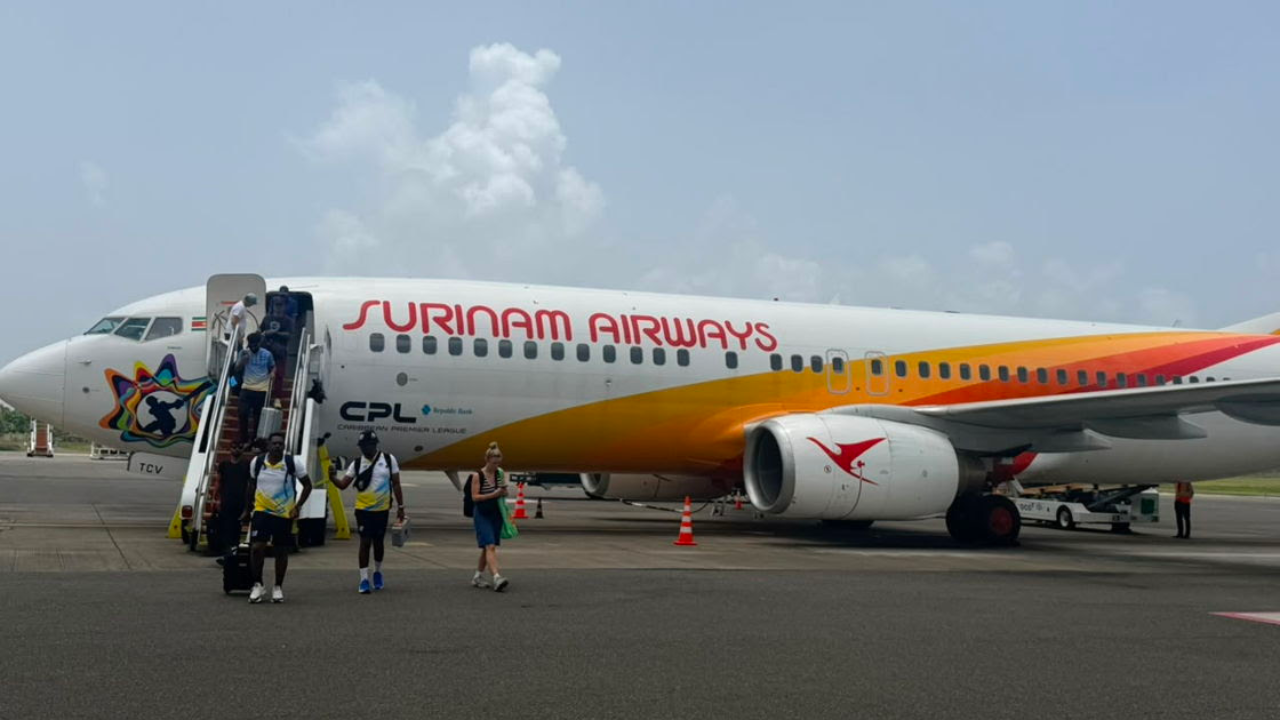 Surinam Airways aircraft featuring Caribbean Premier League branding on the tarmac.