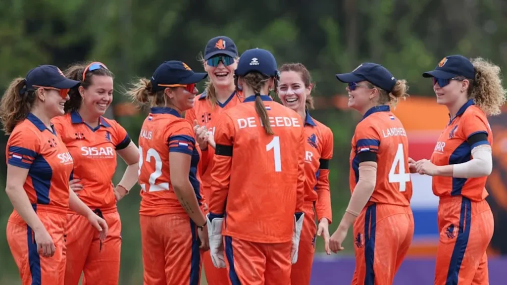 Netherlands women’s cricket team players celebrate together during a match.