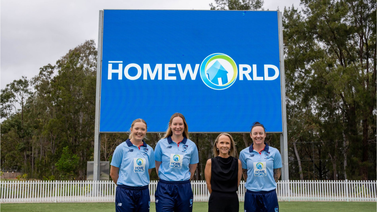Trudi Busch, Chief Marketing Officer of HomeWorld, with three NSW Breakers cricketers in front of a HomeWorld sign.