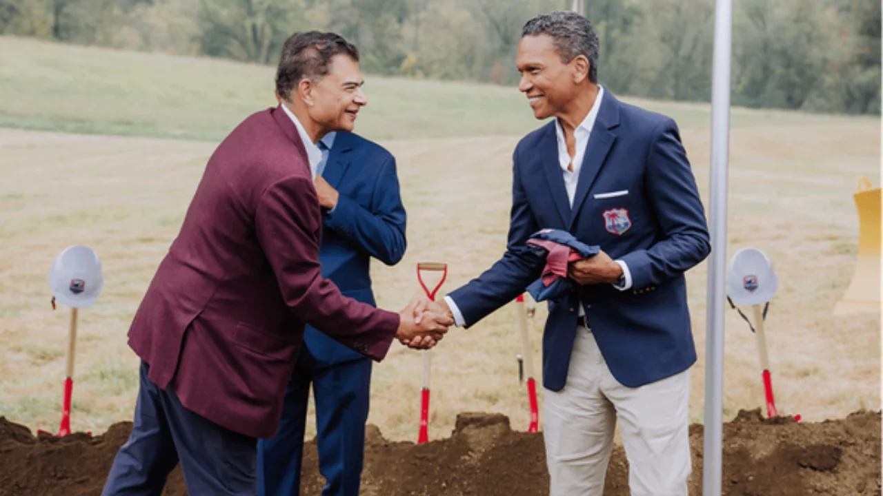Cricket West Indies CEO Chris Dehring shakes hands with Washington Freedom Cricket owner Sanjay Govil at an outdoor ceremony.