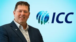 Geoff Allott pictured in a dark blue suit alongside the International Cricket Council (ICC) logo on a light blue background.