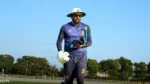 Former Indian cricketer Parvinder Awana wearing cricket training gear, sunglasses and a sun hat while carrying gloves during an outdoor practice session.